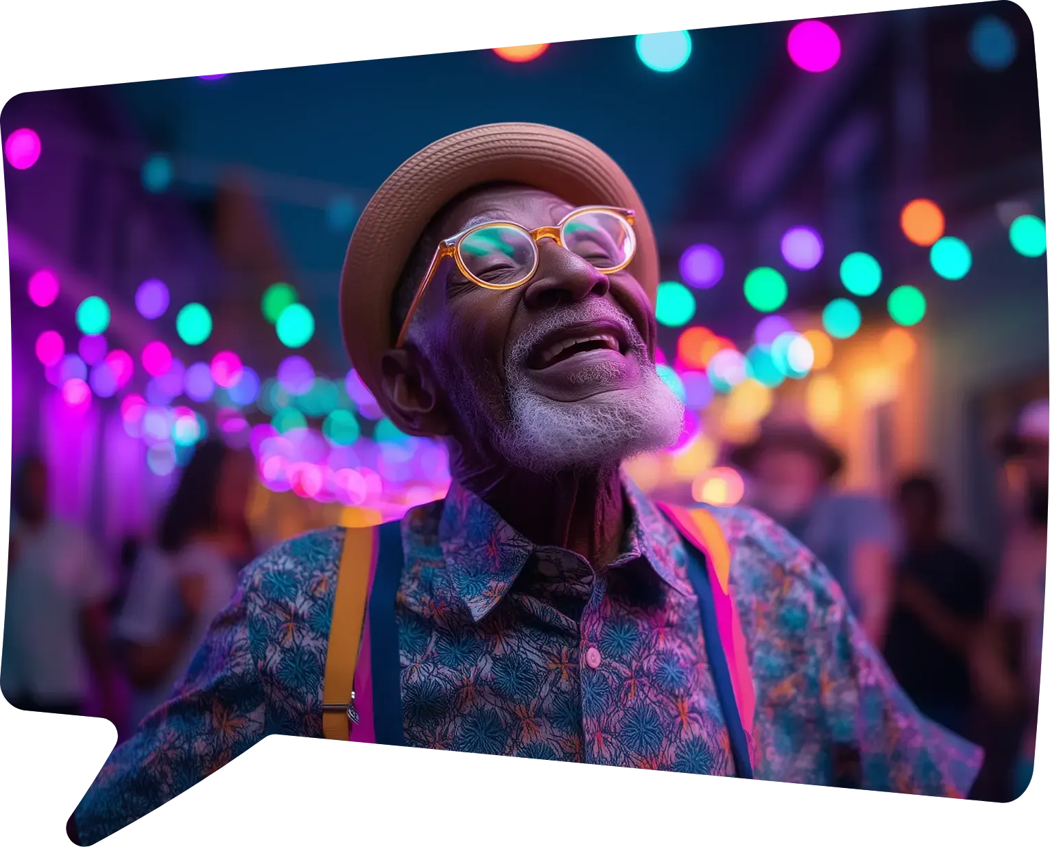An elderly man in a straw hat, round glasses and suspenders laughs under strings of colored lights